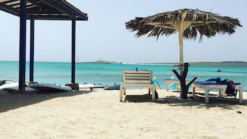 Plage, sable blanc, cabines (en supplément), chaises longues