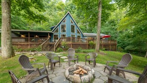 Een lodge met een terras, buitenmeubels en een vuurkuil.