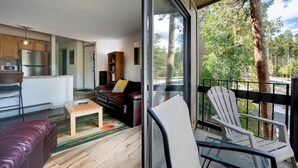 Ein modernes Wohnzimmer mit Sofa, Couchtisch und Blick auf einen Balkon mit einem Sessel.