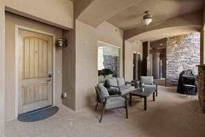 A modern interior with a stone wall, a wooden door, and a seating area with a table and chairs.