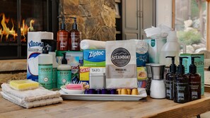 A variety of toiletries and cleaning supplies arranged on a wooden surface near a fireplace. - Exceptional + Hot Tub + Close to Skiing - Peaks Grande (Steamboat Springs)
