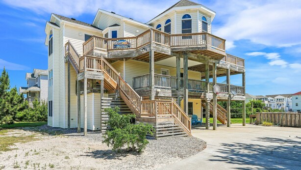 Ein mehrgeschossiges Haus mit einer Holzterrasse und einer Treppe zu den oberen Stockwerken.