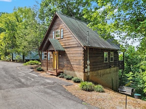 Une cabane en bois avec un porche, une porte et une petite terrasse.