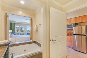 Relax in a spacious room with a bathtub, kitchenette, and large window offering a view of the outside.