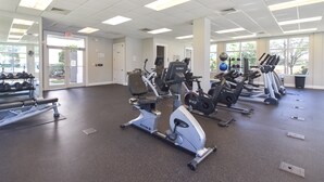 A gym with various cardio machines, weight benches, and dumbbells. - Updated chic, modern beachfront condo w/private balcony! (Destin)