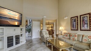 A spacious living room with a flat-screen TV, a sofa set, a coffee table, and a dining area in the background. - 21 Windjammer-Private Pool, views of the 10th tee of Harbour Town Golf Links (Hilton Head Island)