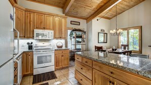 A kitchen with wooden cabinets, a granite countertop, and a built-in oven. - Unwind in Alpine Bliss! River Views & Convenient Walkability to Town/Slopes (Breckenridge)