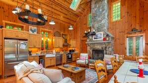 Un acogedor interior de cabaña con chimenea de piedra, una mesa de comedor de madera y una sala de estar con sof á.