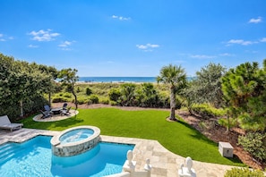 A swimming pool with a hot tub, surrounded by a well-maintained lawn and various trees. - 31A Dune Lane - This DIRECT oceanfront home will take your breath away! (Hilton Head Island)