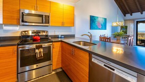 Una cocina moderna con electrodomésticos de acero inoxidable, armarios de madera y una isla grande con fregadero.
