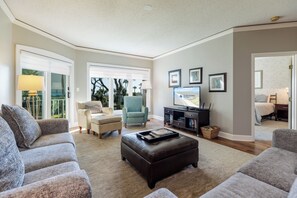 A spacious living room with a large window, a television, and a comfortable seating area. - Gorgeous  two bedroom end unit villa in Palmetto Dunes on Hilton Head Island (Hilton Head Island)