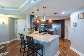 A modern kitchen with a central island, stainless steel appliances, and pendant lighting. - Gorgeous  two bedroom end unit villa in Palmetto Dunes on Hilton Head Island (Hilton Head Island)