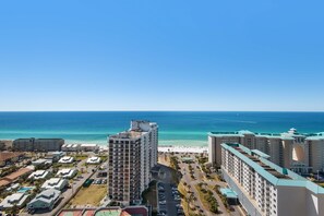 A resort with multiple buildings, a beach, and a view of the ocean.