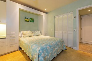 A bedroom with a bed, a wardrobe, and a closet. - Beachfront Living - Makena Surf E-202 - Mesmerizing Views & Tropical Landscapes (Makena, Maui)