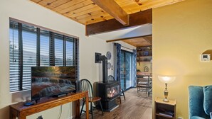 A cozy living room with a fireplace, wooden furniture, and a television.