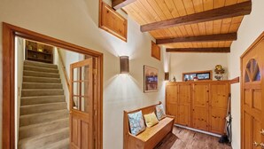 A wooden staircase leading to a landing with a bench and a wall-mounted light fixture.