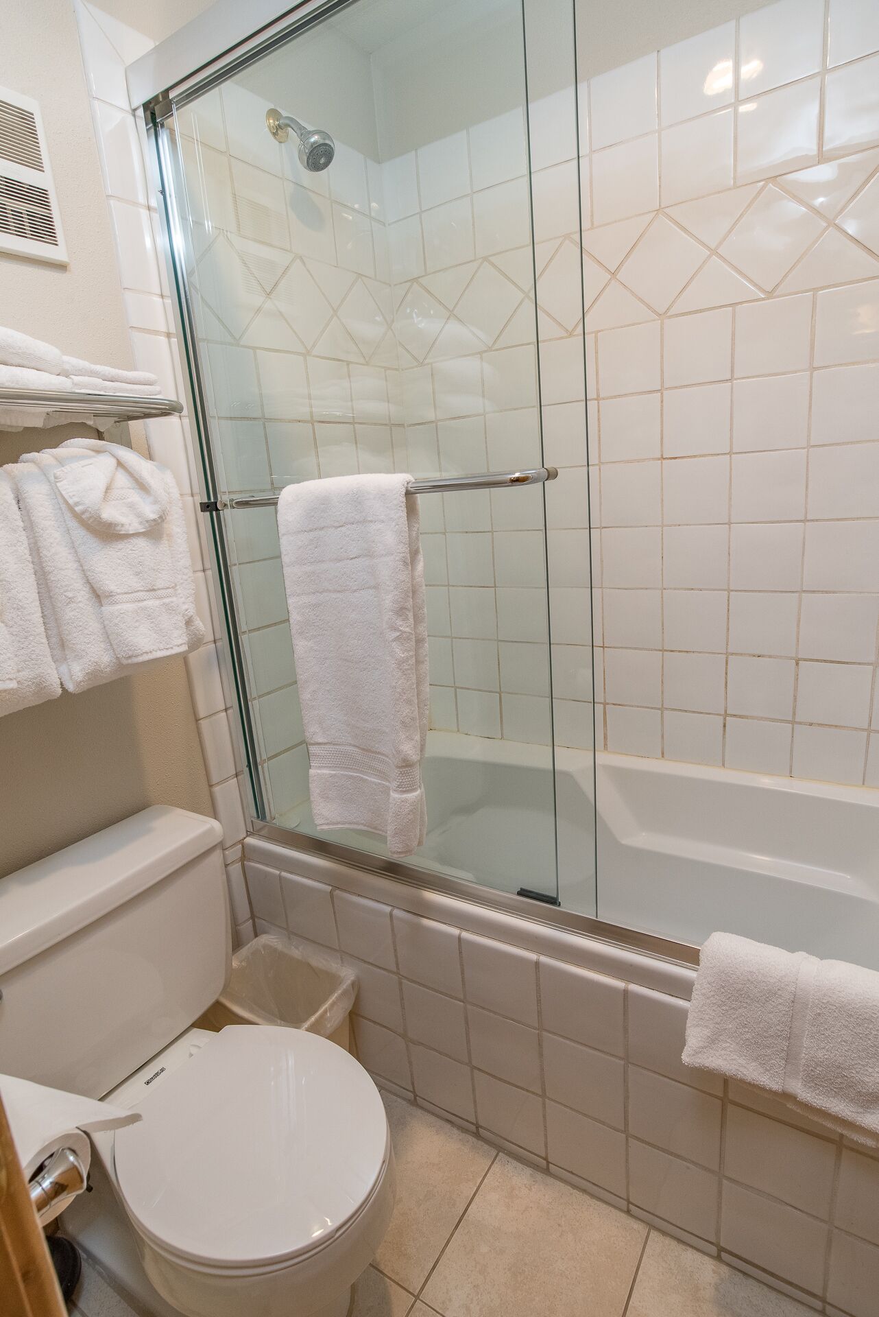 Een badkamer met een douchecabine van glas, een bad en een toilet.