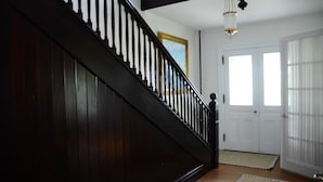 A staircase with dark wood railings and a white door at the bottom. - Aurora Escape: "Spectacular Design Awaits You!" (Aurora)