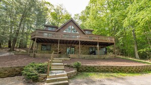 A two-story cabin with a balcony, surrounded by trees. - Deep Creek Dog Friendly Cabin w/ Dock & Fireplace (Swanton)