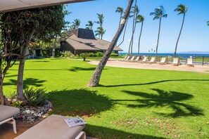 A well-maintained lawn with a pool area, lounge chairs, and a view of the ocean. - Ma'alaea Surf Unit C4-1BR Ground Floor Beachfront Condo, AC, Wifi, Kitchen (Kihei)