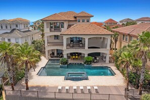 A multi-story house with a swimming pool, outdoor seating, and palm trees. - 5 O'Clock Somewhere - Beach House with Gulf Views & Private Pool (Destin)