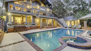 Une maison à deux étages avec une piscine et un jacuzzi.