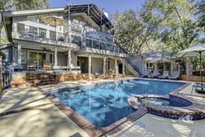 Une maison à deux étages avec une piscine et un jacuzzi.