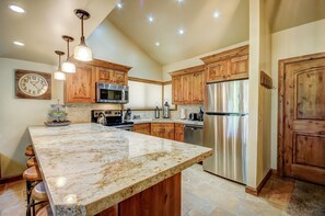 A kitchen with wooden cabinets, a marble countertop, stainless steel appliances, and pendant lighting. - Hidden Creek 29D: 3 Bedroom 3 bathroom Townhome Very close to the Cabriolet Lift (Park City)