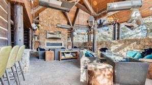 An outdoor seating area with stone walls, a fireplace, and modern furniture. - Ritz Carlton 1BR Ski-in/out - 2 Queen Beds - Sleeps 4 (Beaver Creek)