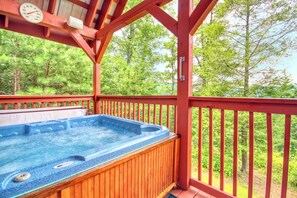 A hot tub in a wooden deck with a wooden railing and a view of a forest. - Privacy~Sunset View~Pet Friendly~Pool Table~Air Hockey (SEVIERVILLE)