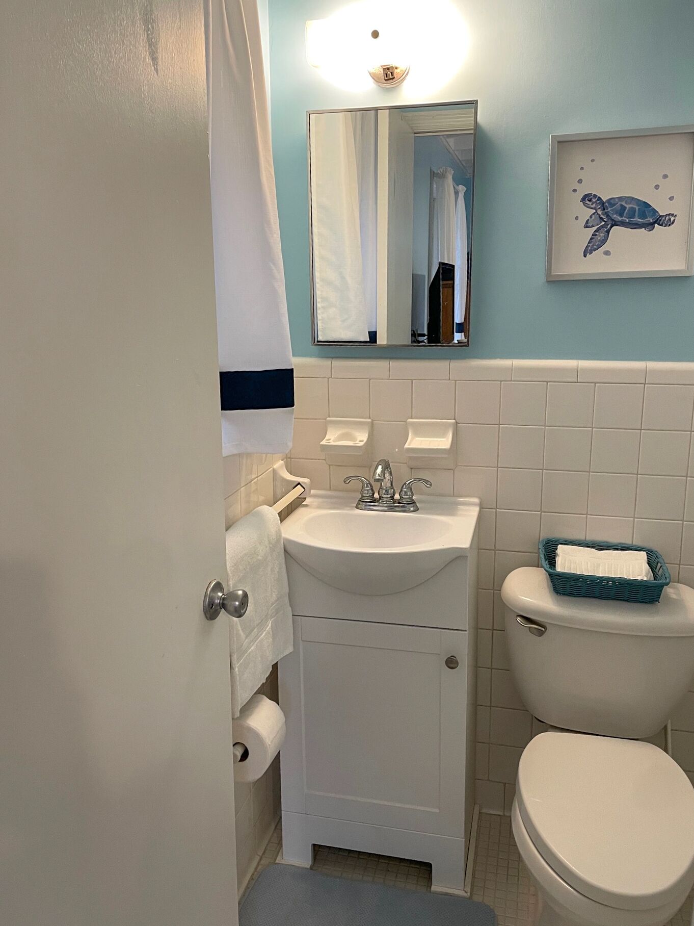 A bathroom with a sink, mirror, and toilet.