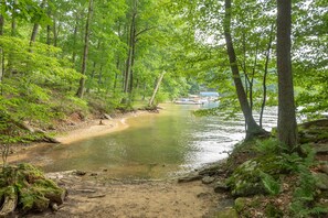 A river surrounded by dense green trees and a sandy path. - Hidden Retreat w/ Hot Tub & Scenic Views (McHenry)