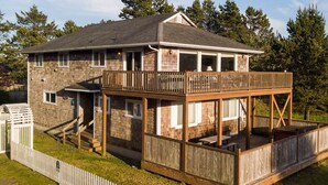 A two-story house with a deck and a covered porch. - HOT TUB, Game Room, Walk to Beach, Fenced Yard, Dogs Ok (45th) (Long Beach)