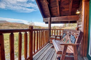 A wooden deck with a bench, a railing, and a view of a hilly landscape. - Pigeon Forge | Pet Friendly | Mountain Views | Hot Tub | Fireplace | WiFi (Pigeon Forge)
