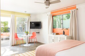 Relax in a stylish room with a large bed, flat-screen TV, and a small table for two.