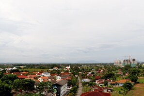 A residential area with houses, a road, and construction cranes in the distance. - Lagenda Condominium (Malacca City)