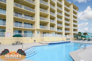 A multi-story hotel with balconies, a swimming pool, and outdoor seating. - Indies 410 | 3BR/3BA Beachfront Condo | Sleeps 6 | Wraparound Balcony & Pool (GULF SHORES)