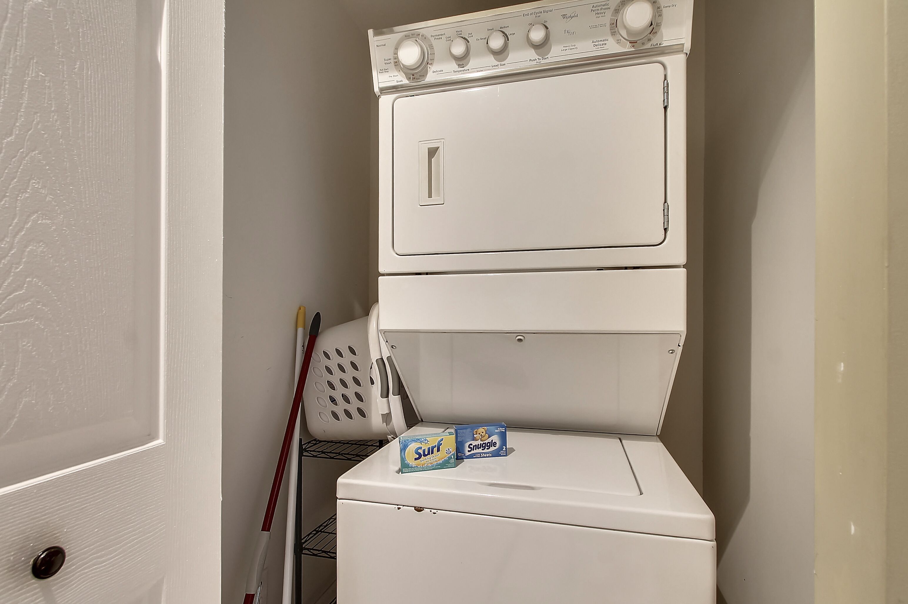 Lavadora y secadora apilables blancas y compactas con panel de control superior.