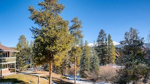 A lodge with a wooden deck and a view of snow-covered mountains. - Cozy Top Floor Unit w/ Lots of Windows. Ski In, Steps from Main Street | PM8D (Breckenridge)