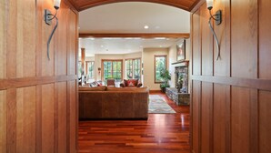A hallway with wooden paneling and a large, plush sofa in the center. - Drake Park Villa - River Front on Mirror Pond & Drake Park, Exquisite, Gourmet Kitchen (Bend)