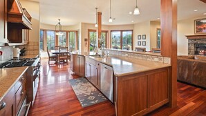 A spacious kitchen with wooden cabinets, a granite countertop, and a large island. - Drake Park Villa - River Front on Mirror Pond & Drake Park, Exquisite, Gourmet Kitchen (Bend)