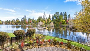 A serene park with a lake, surrounded by trees and a fence. - Drake Park Villa - River Front on Mirror Pond & Drake Park, Exquisite, Gourmet Kitchen (Bend)