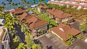 A resort with multiple buildings, a swimming pool, and a view of the ocean. - 🏖️Top Floor Kona Condo w/ Ocean Views + Full A/C (Kailua Kona)