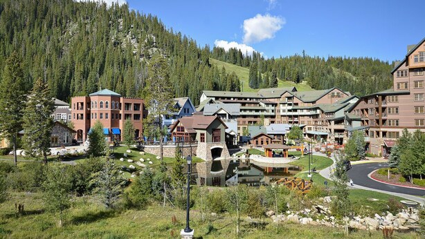A resort with multiple buildings, a central courtyard, and a mountain backdrop.