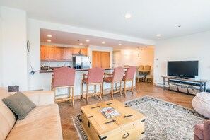 Relax in this stylish living space with a comfortable sofa, dining area, and fully equipped kitchen.