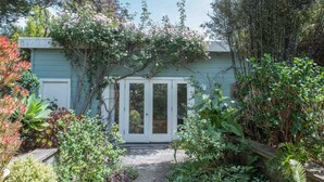 A garden with a variety of plants and a small building with a door. - Adorable Cozy Studio (Stinson Beach)