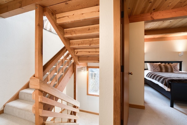A wooden staircase leading to a bedroom with a bed and a window. - Juniper at Alpine - Private Hot tub, Pet Friendly & Amazing Views! (Alpine Meadows)