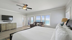 A bedroom with a bed, a ceiling fan, a television, a dresser, and a window with blinds. - Las Olas - Oceanfront Vacation Home with Private Pool Space & Gulf Views (Miramar Beach)