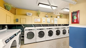 A laundry facility with multiple washing machines, a fire extinguisher, and informational signs. - Beautiful ocean views, remodeled 2bdrm penthouse condo, C303 North Coast Village (Oceanside)
