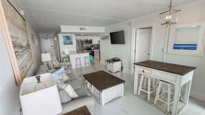 Un amplio espacio habitable con cocina, comedor y bar.